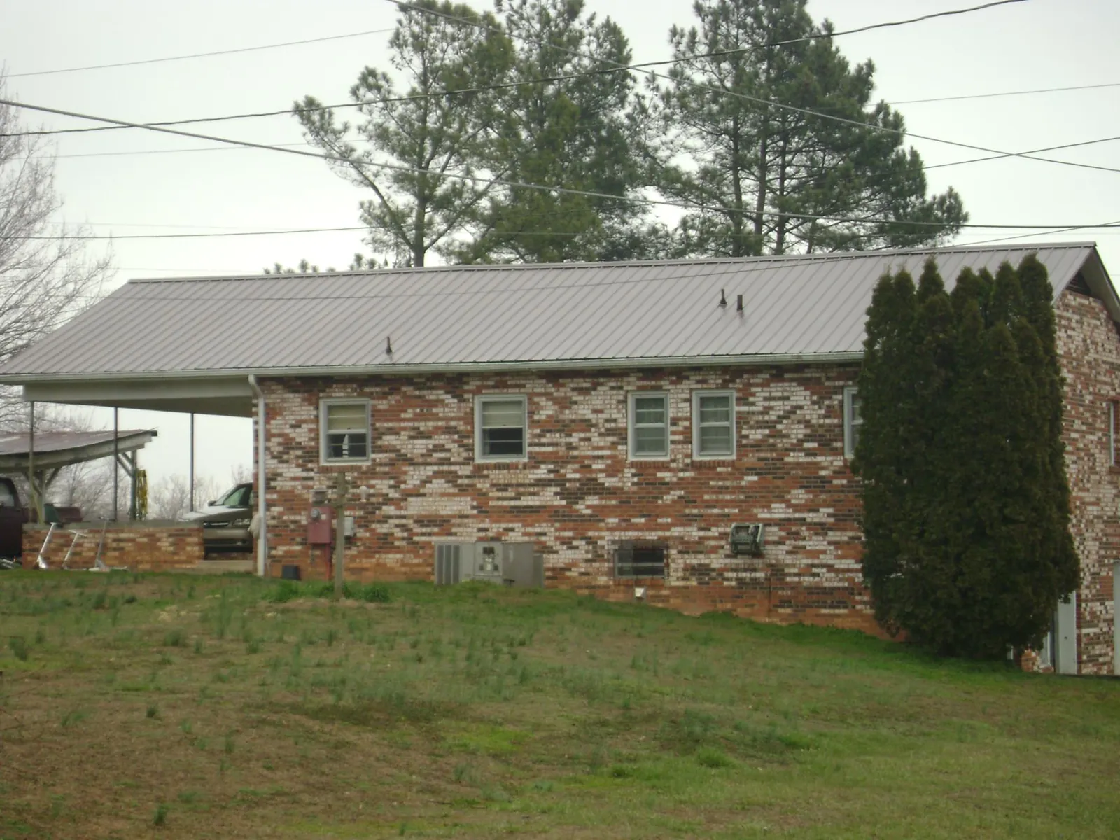 Gray metal roof on a brick split level home with a carport in Windsor